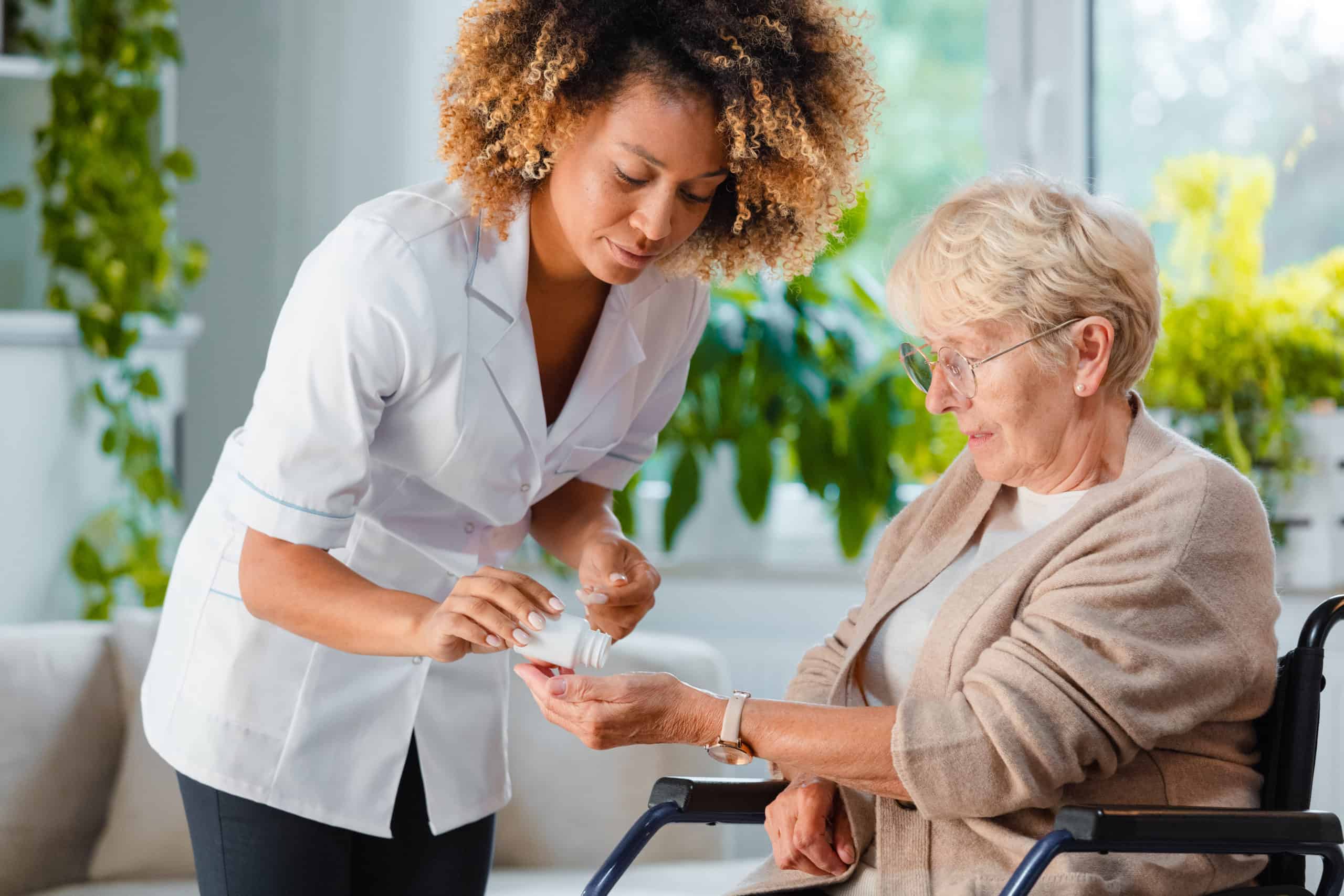 Female nurse dispensing medication to older female